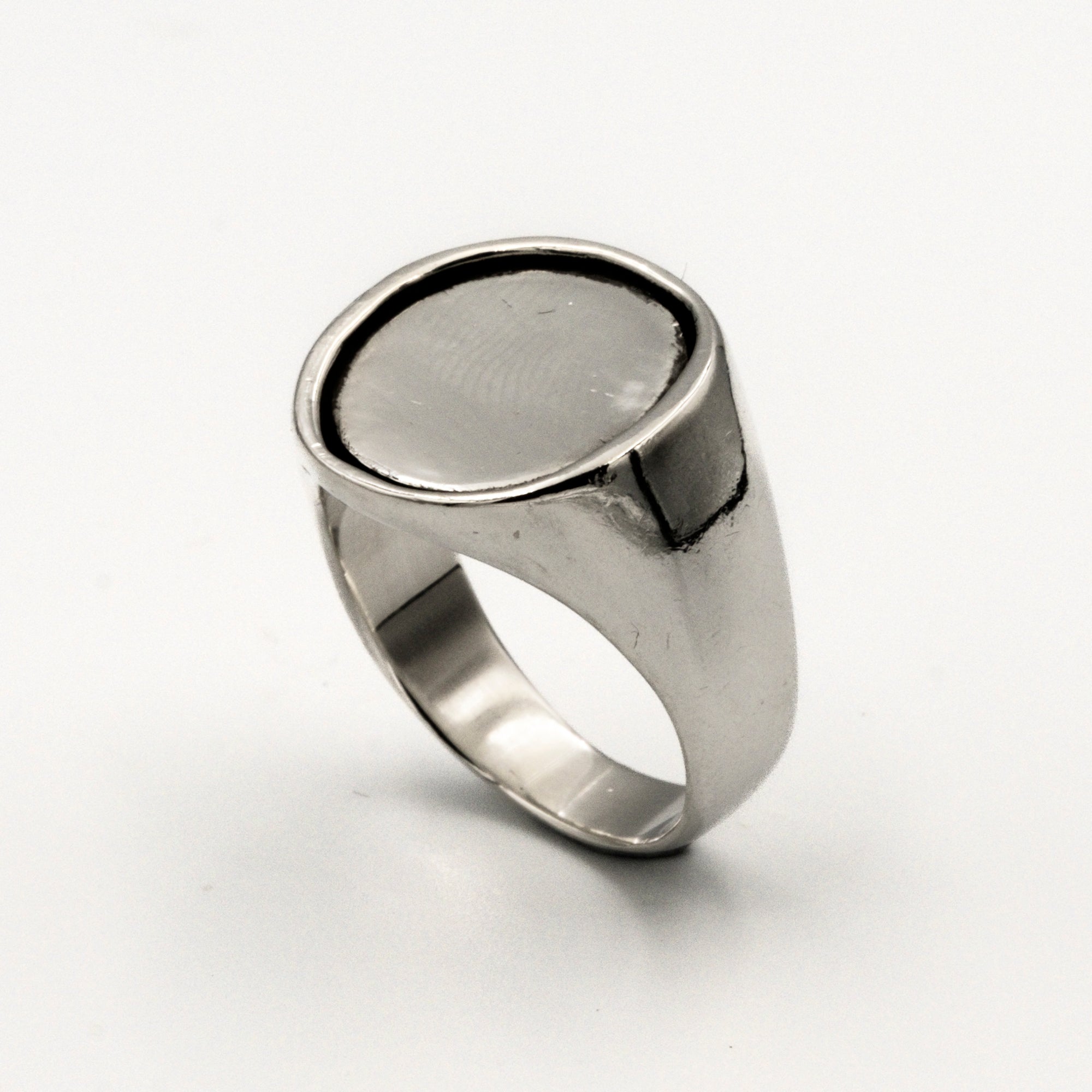 Silver ring with a silver coin inlay on a white background