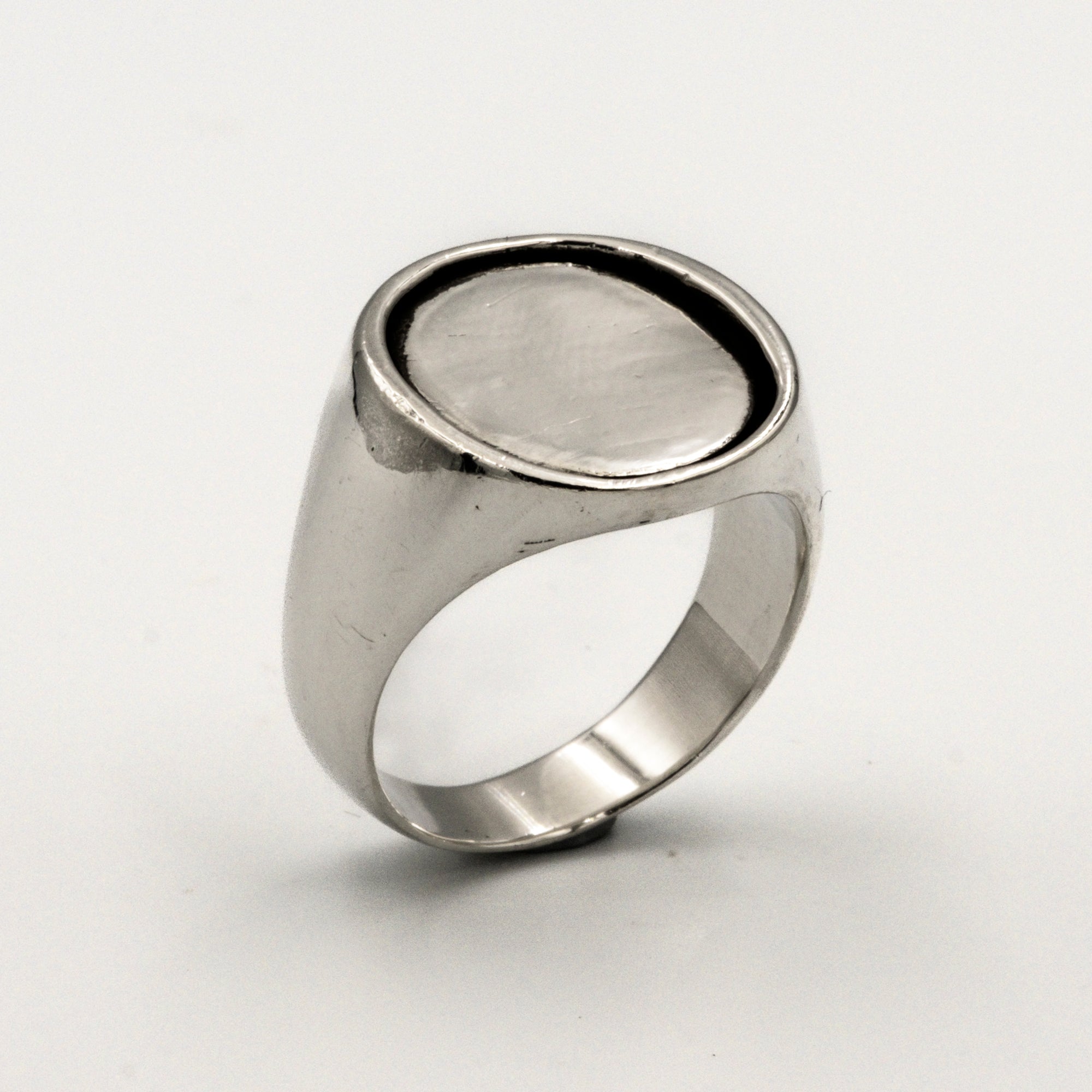 Silver ring with a silver coin inlay on a white background