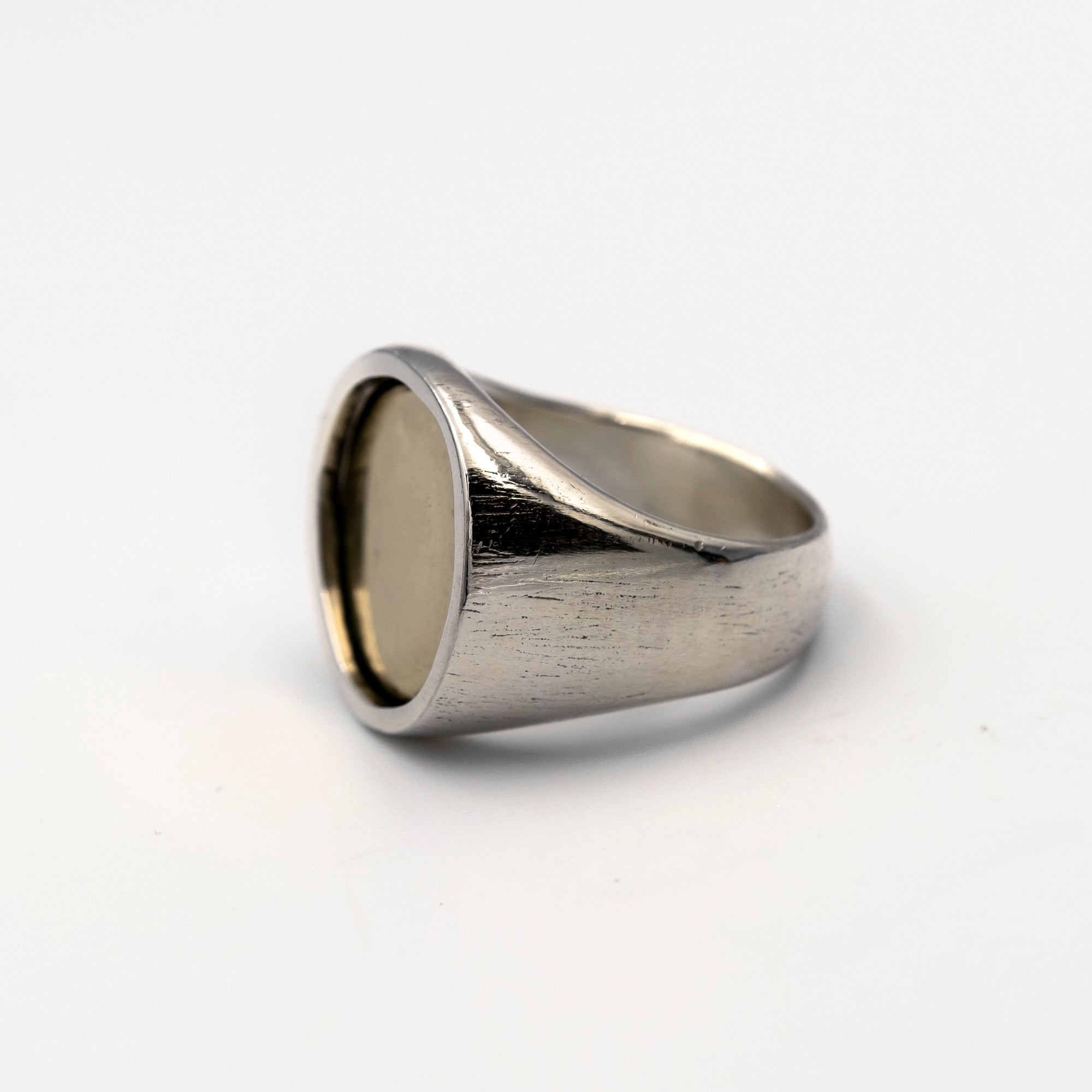 Silver ring with a gold coin inlay on a white background