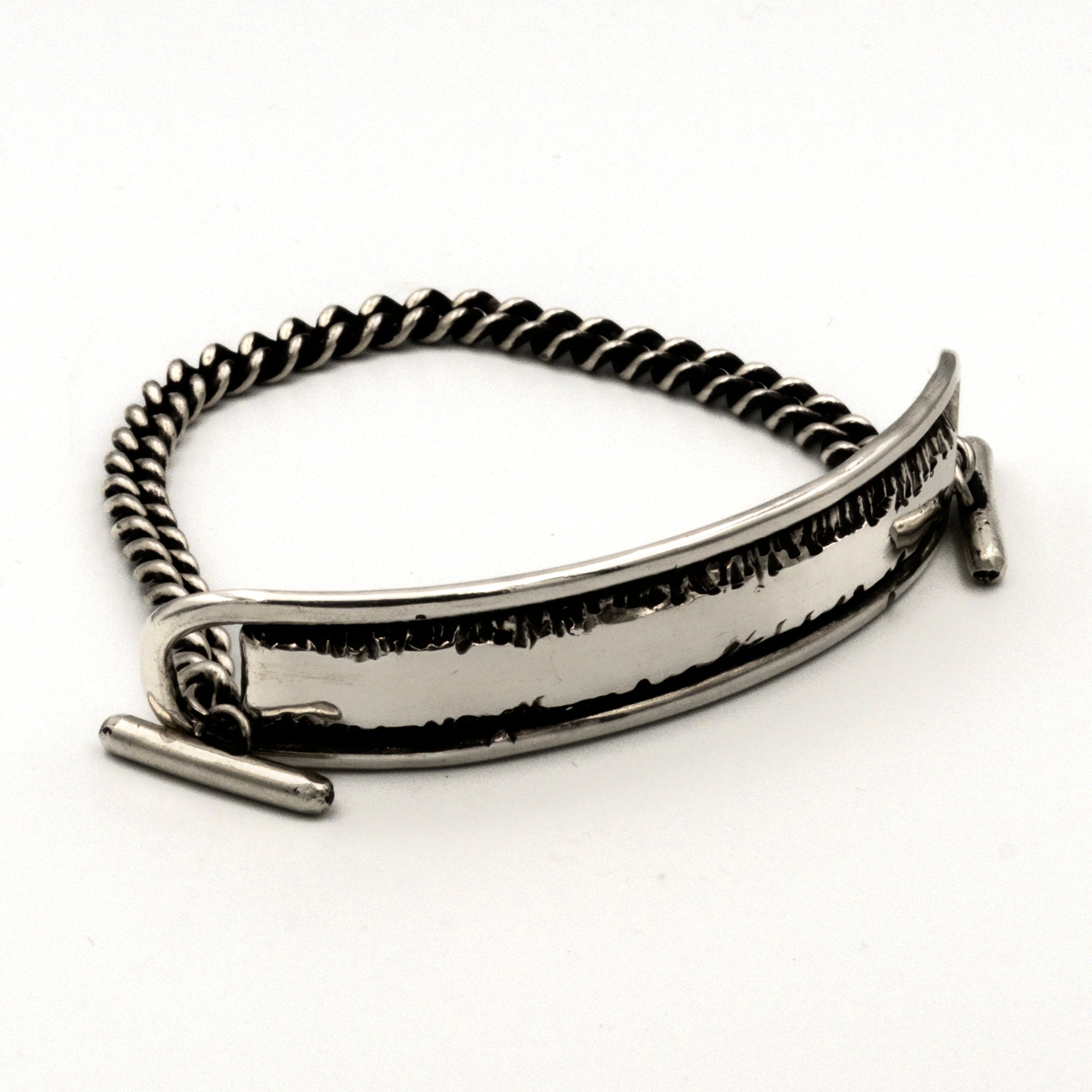 Silver bracelet with a textured band on a white background