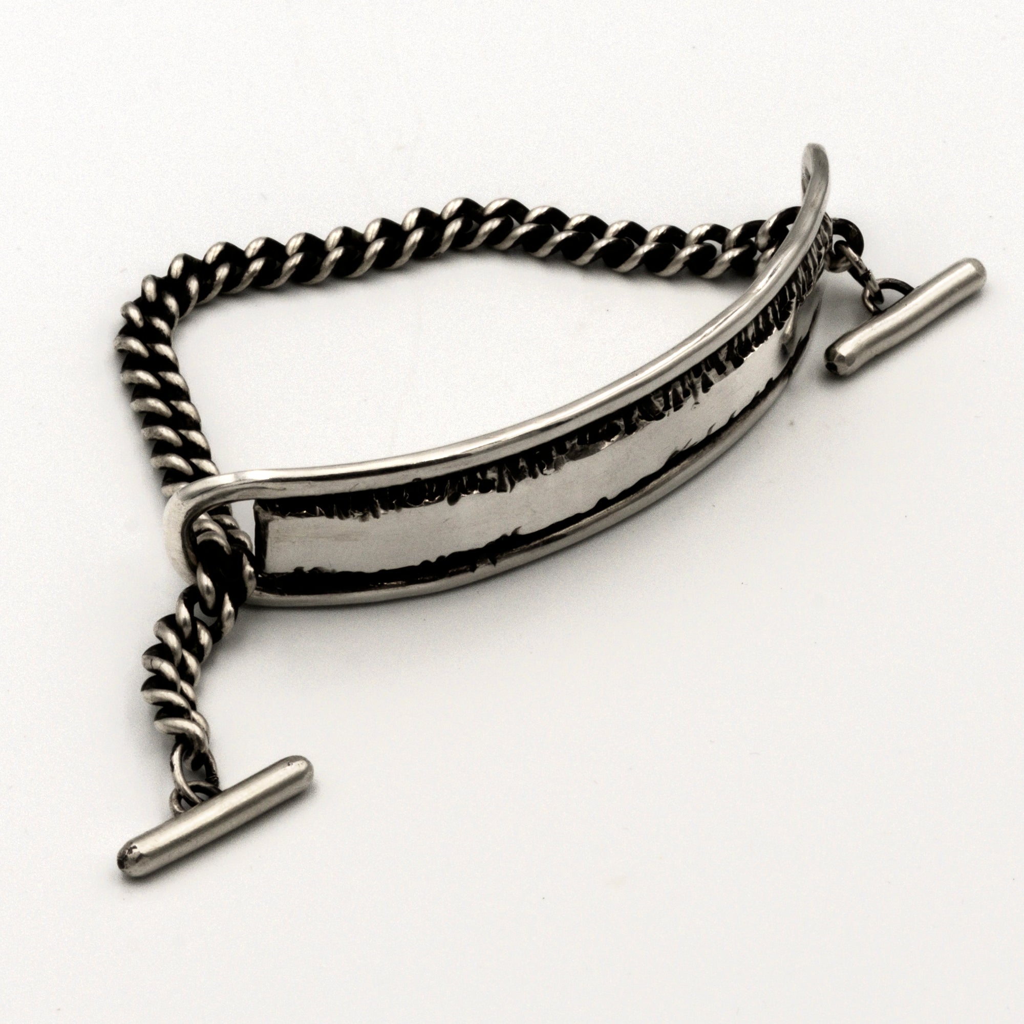 Silver bracelet with a textured band on a white background