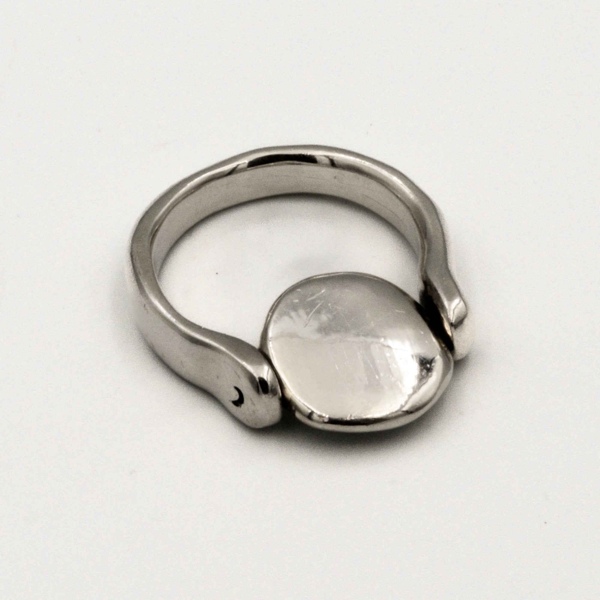 Silver ring with a smooth, oval-shaped tablet on a light gray background
