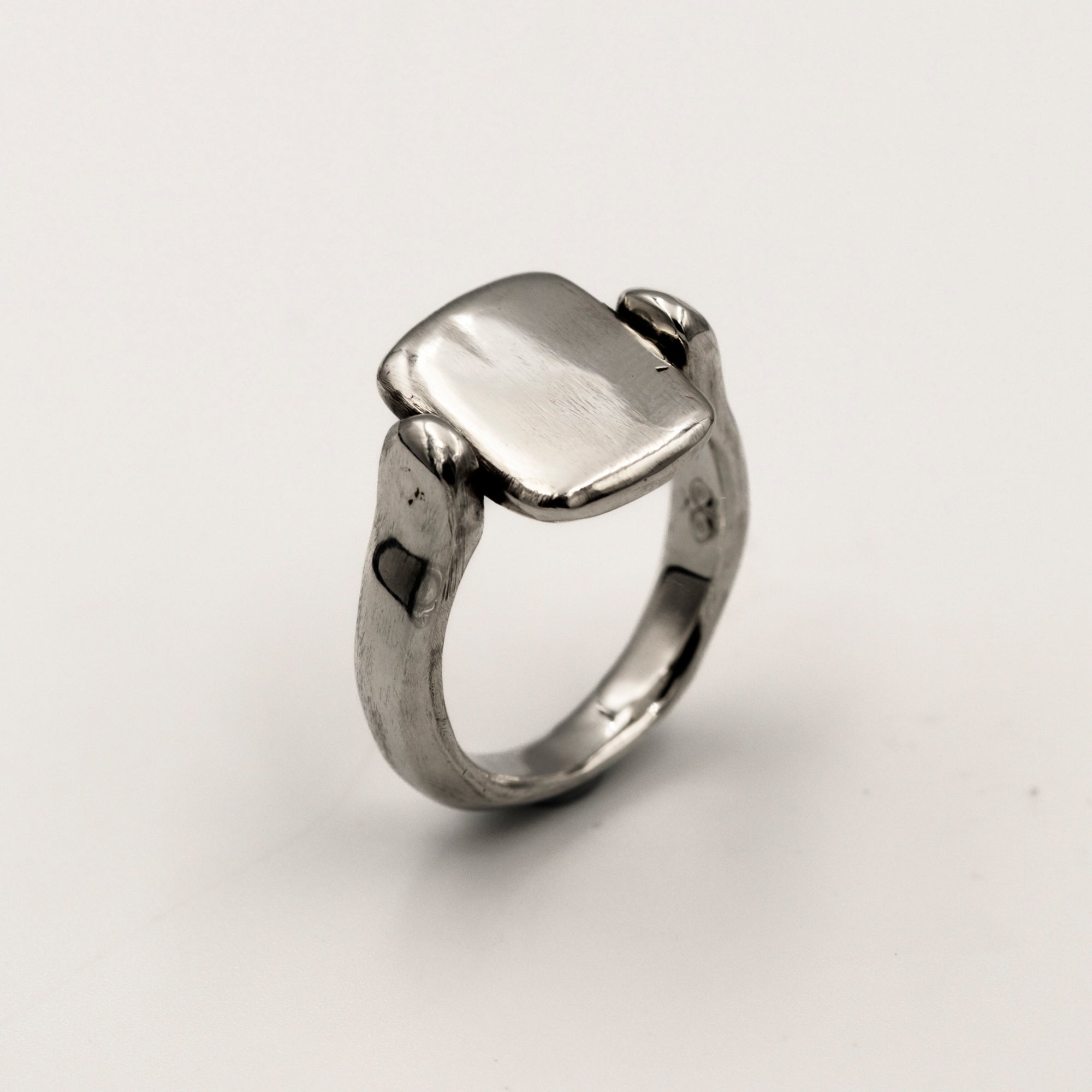 Silver ring with a rectangular tablet on a light white background