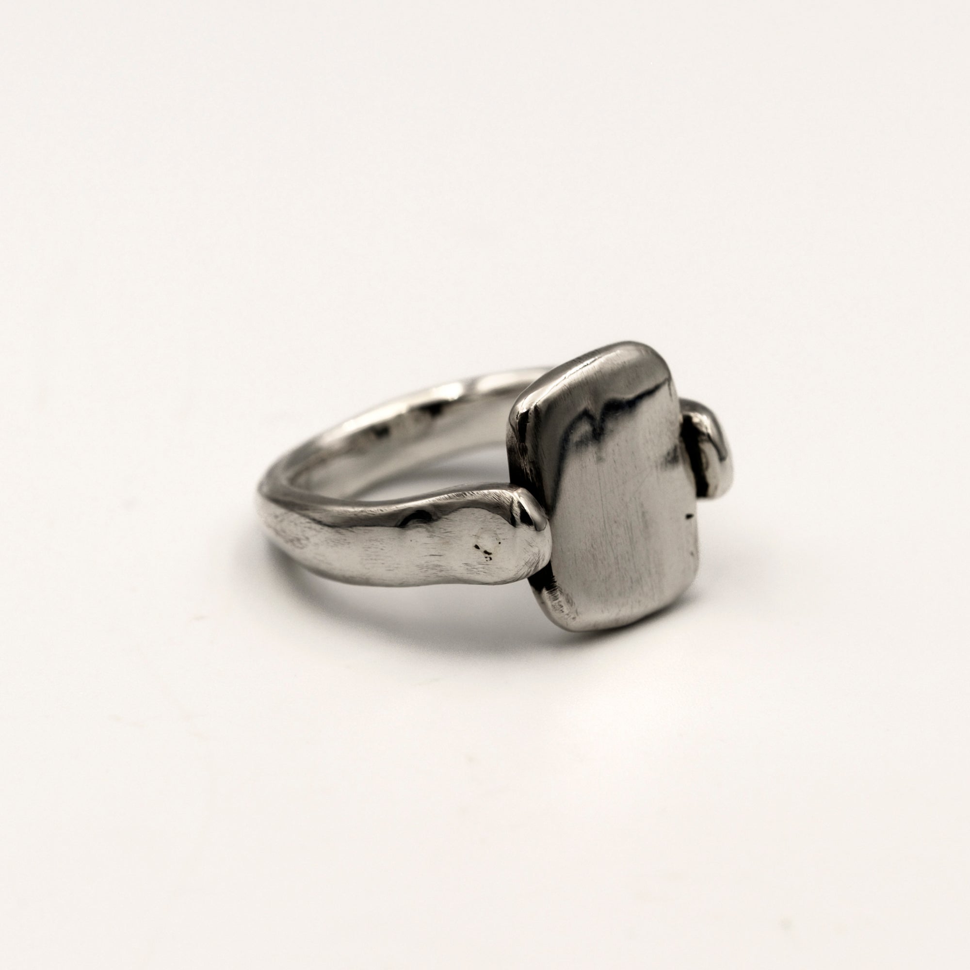 Silver ring with a rectangular tablet on a light white background