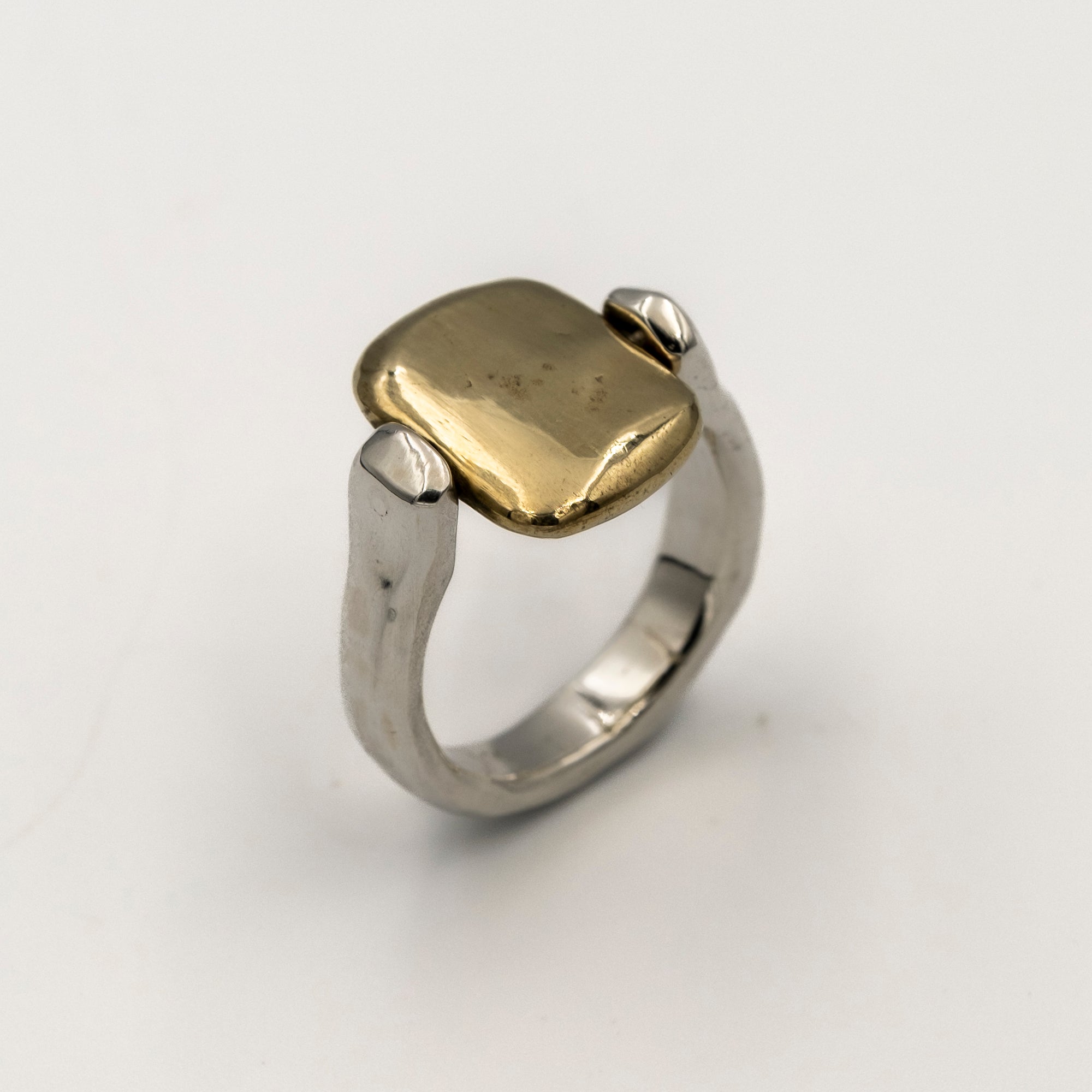 Two-tone ring with gold and silver components on a white background