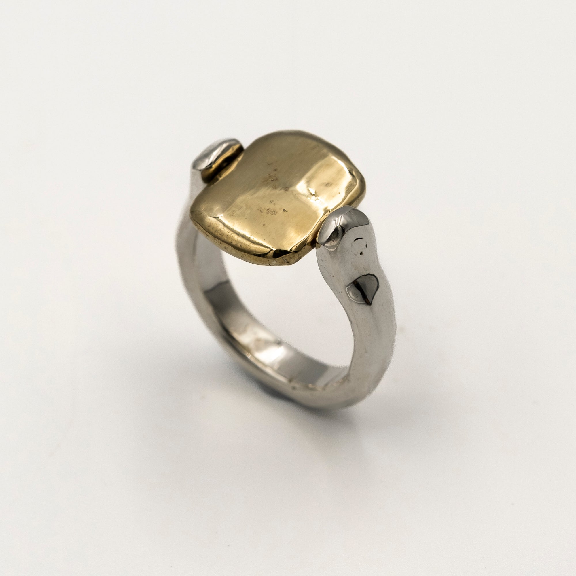 Two-tone ring with gold and silver components on a white background