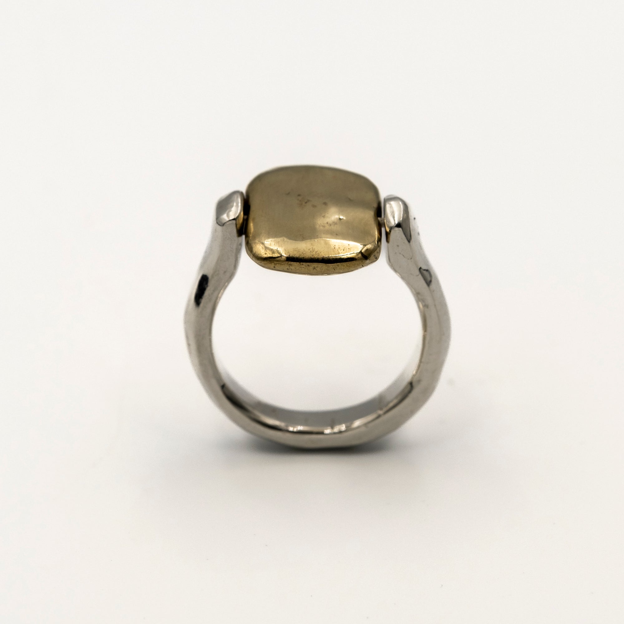 Two-tone ring with gold and silver components on a white background