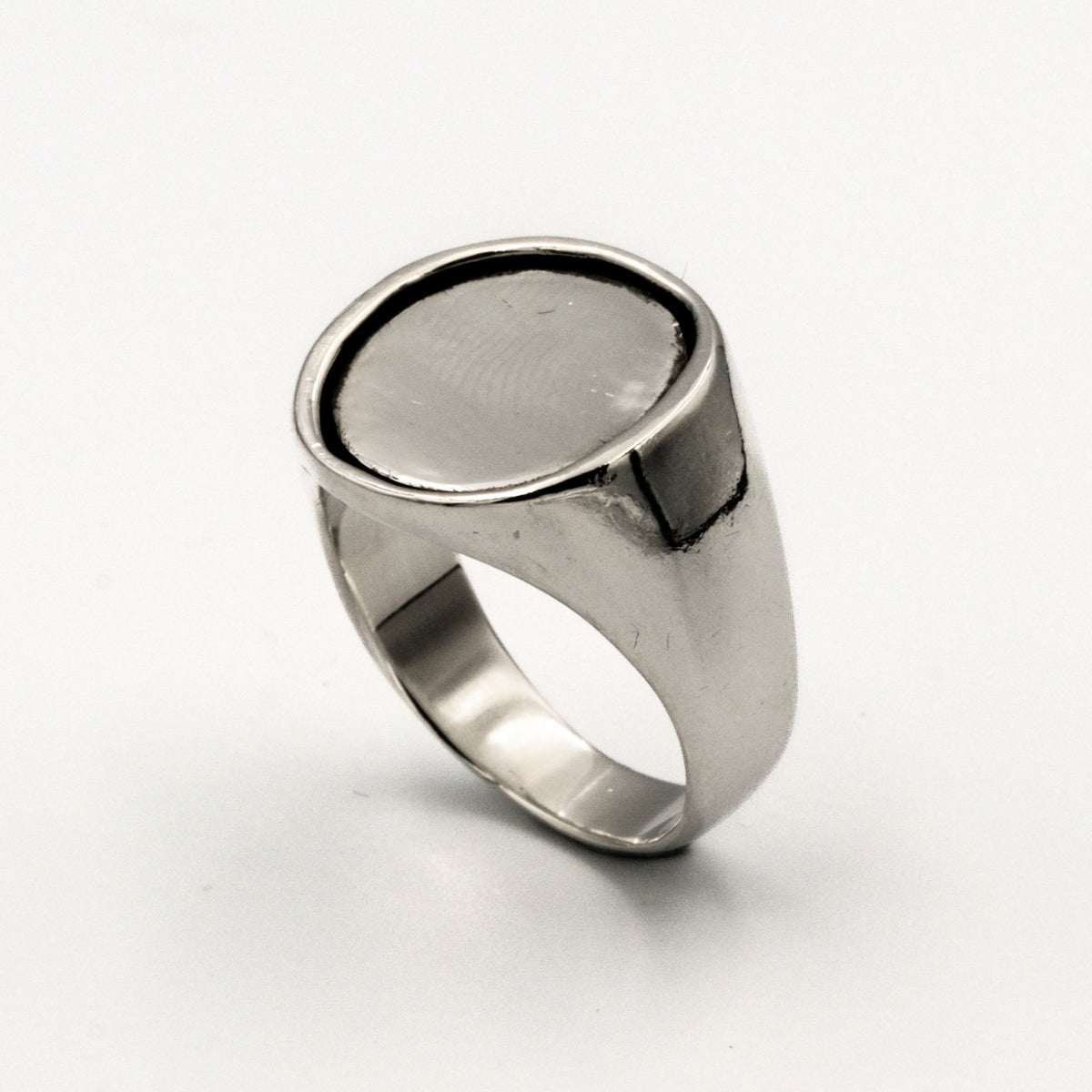 Silver ring with a silver coin inlay on a white background