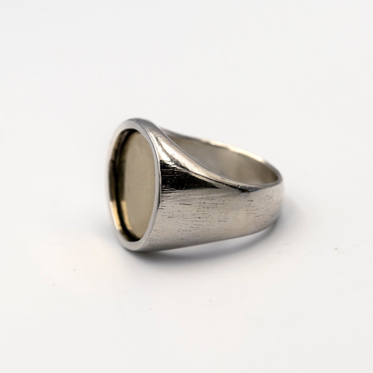 Silver ring with a gold coin inlay on a white background