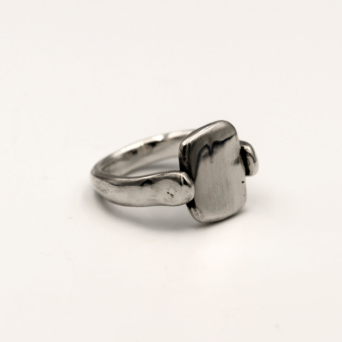 Silver ring with a rectangular tablet on a light white background
