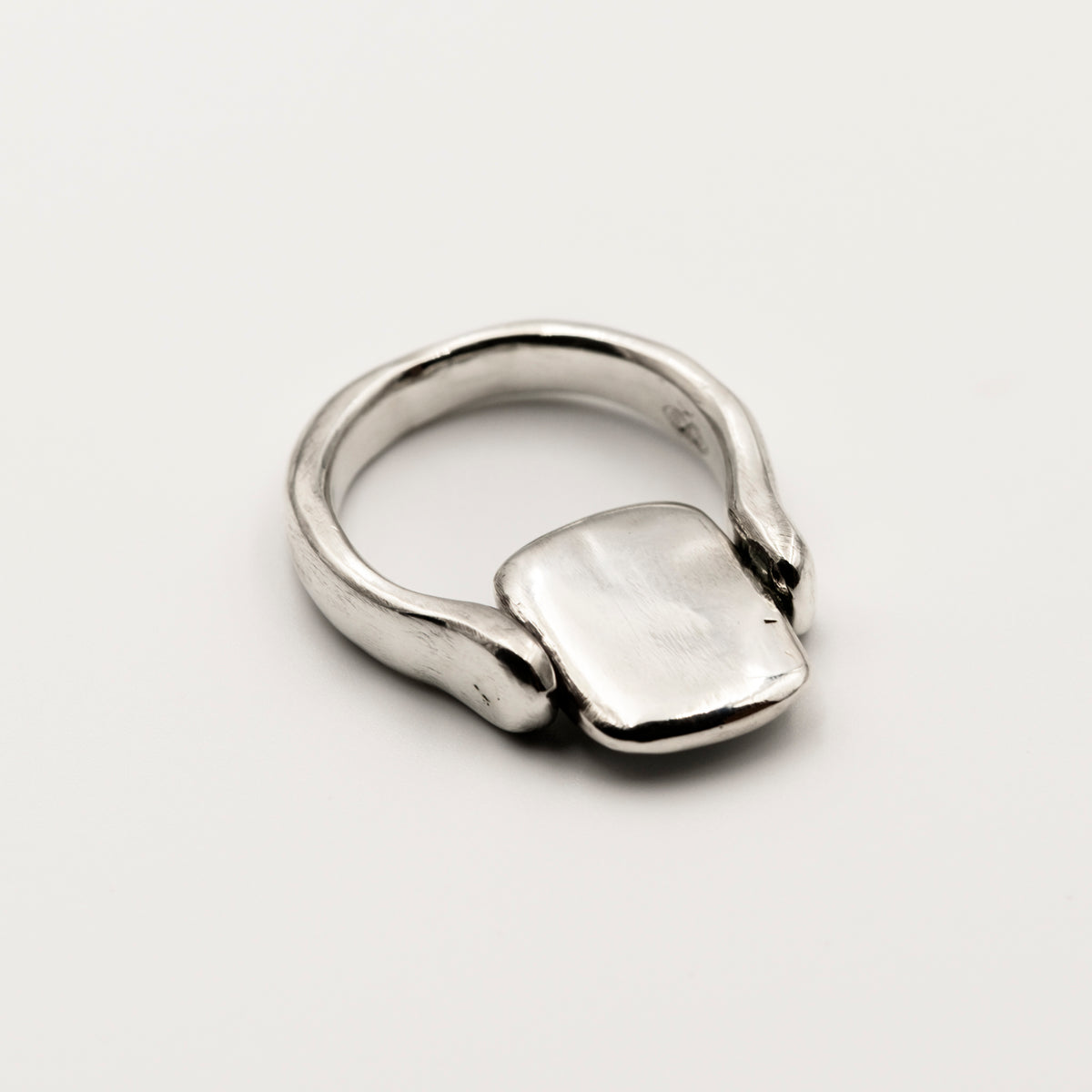 Silver ring with a rectangular tablet on a white background