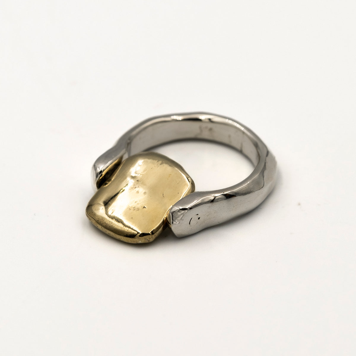 Two-tone ring with gold and silver components on a white background